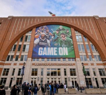 Exterior of American Airlines Center in Dallas, home of the Mavericks, with a Mavs and Stars banner above the west entrance