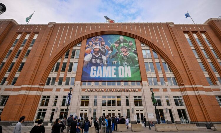 Exterior of American Airlines Center in Dallas, home of the Mavericks, with a Mavs and Stars banner above the west entrance