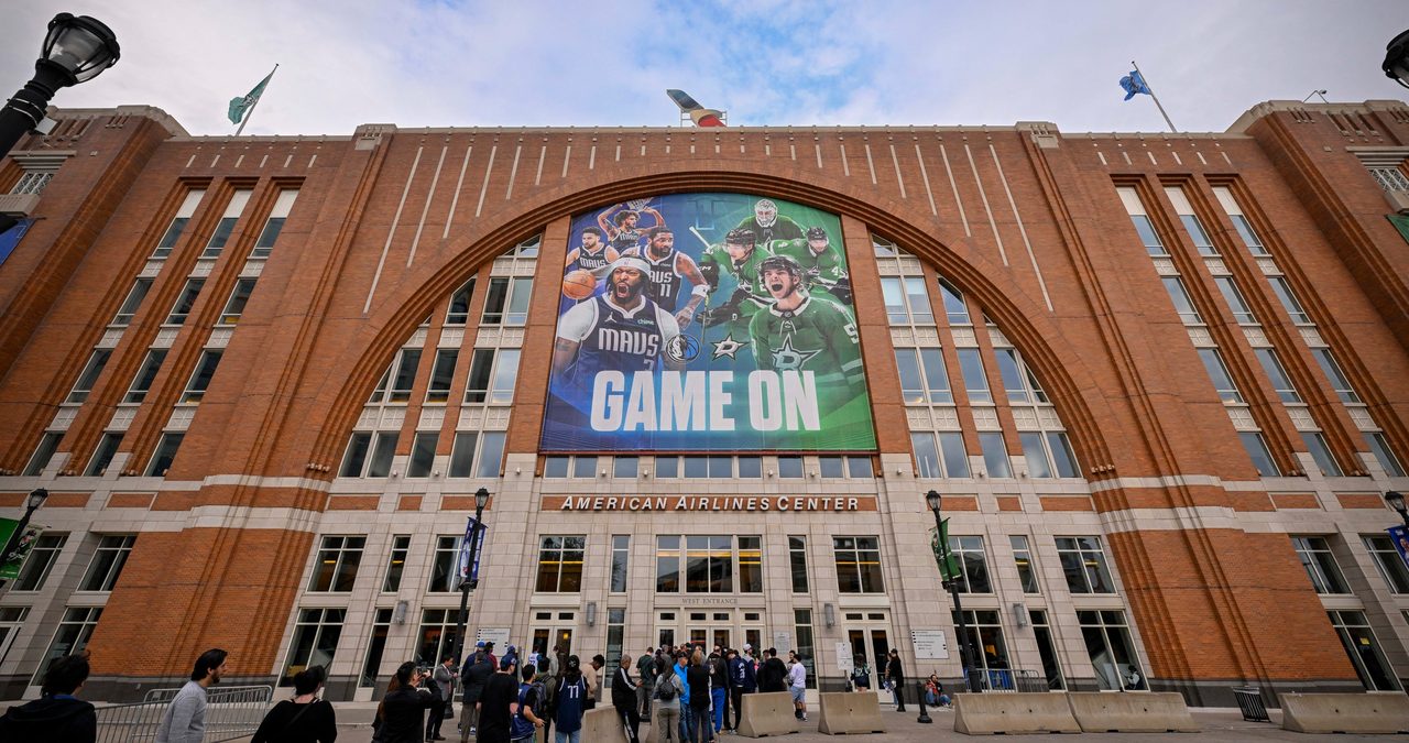 Exterior of American Airlines Center in Dallas, home of the Mavericks, with a Mavs and Stars banner above the west entrance