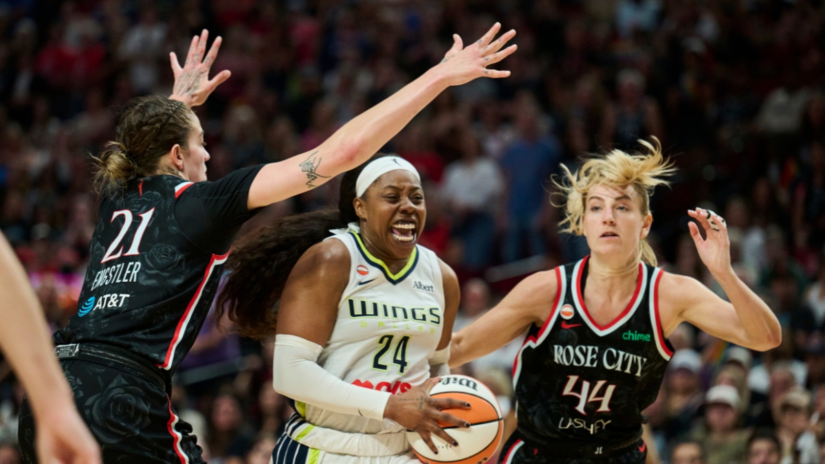 Dallas Wings guard Arike Ogunbowale drives to the basket between Portland Fire defenders Emily Engstler and Karlie Samuelson during the second half at Moda Center on July 22, 2026.