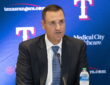 Texas Rangers general manager Chris Young speaks into a microphone in front of a Rangers backdrop at Globe Life Field.