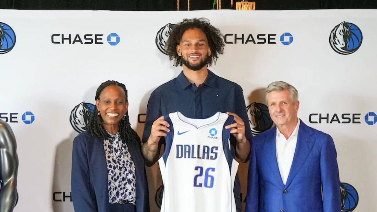 Dereck Lively II holds a Dallas Mavericks jersey with the Chase patch alongside Rick Welts and Pauline Saunders at the partnership announcement