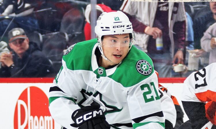 Dallas Stars left wing Jason Robertson (21) skates during a game, with an opposing player in an orange uniform nearby.