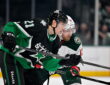 Dallas Stars left wing Jason Robertson and Minnesota Wild center Yakov Trenin skate stride for stride looking for the puck.