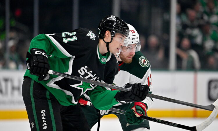 Dallas Stars left wing Jason Robertson and Minnesota Wild center Yakov Trenin skate stride for stride looking for the puck.