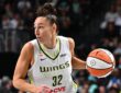 Dallas Wings forward Jessica Shepard dribbles the ball up the court in a white road jersey