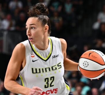 Dallas Wings forward Jessica Shepard dribbles the ball up the court in a white road jersey