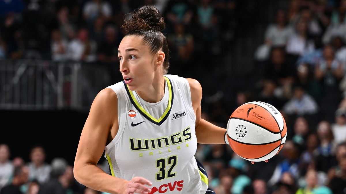 Dallas Wings forward Jessica Shepard dribbles the ball up the court in a white road jersey