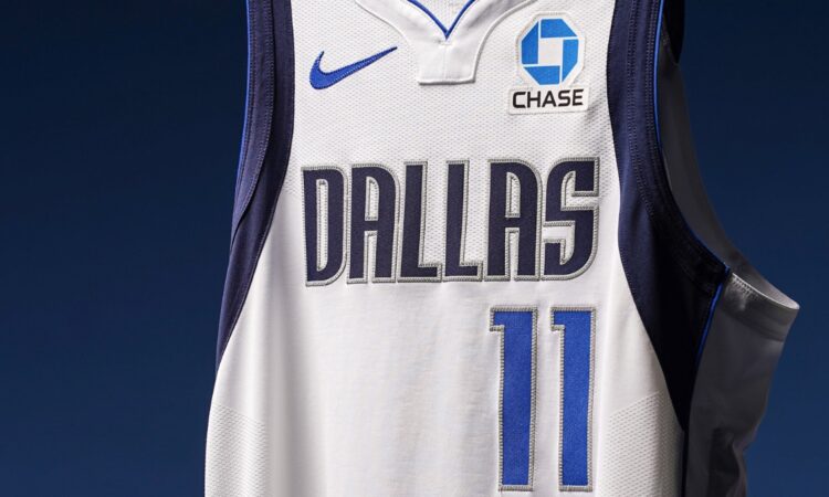 Close-up of a Dallas Mavericks white jersey showing the No. 11 and a new Chase logo patch on the left chest