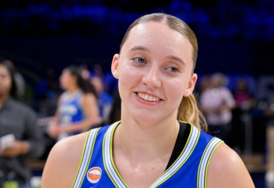 Dallas Wings guard Paige Bueckers smiles on the court at College Park Center after a game against the Las Vegas Aces.