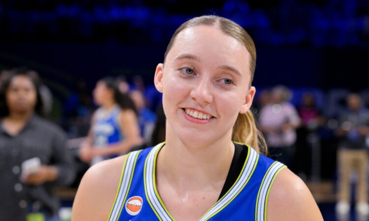 Dallas Wings guard Paige Bueckers smiles on the court at College Park Center after a game against the Las Vegas Aces.
