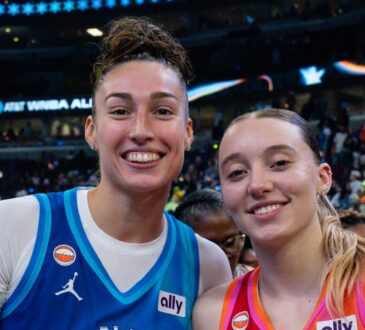Jessica Shepard, in a blue Team Spoon jersey, and Paige Bueckers, in an orange Team Coop jersey, stand together and smile on the court after the 2026 WNBA All-Star Game.