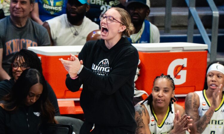 Dallas Wings guard Paige Bueckers claps and cheers from the sideline as guards Sug Sutton and Aziaha James applaud from the bench during a game against the New York Liberty at College Park Center.