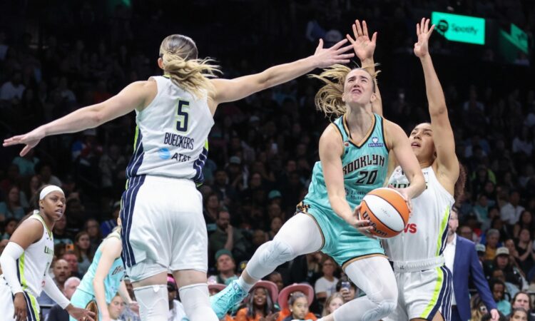 New York Liberty guard Sabrina Ionescu drives to the basket between Dallas Wings defenders Paige Bueckers and Azzi Fudd in the fourth quarter at Barclays Center