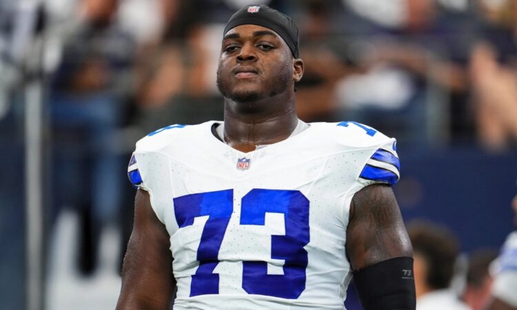Dallas Cowboys offensive lineman Tyler Smith wearing his No. 73 white jersey and a black skull cap during pregame warmups