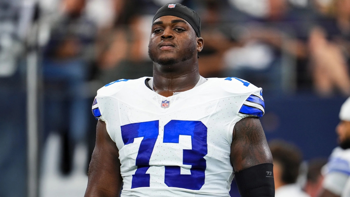 Dallas Cowboys offensive lineman Tyler Smith wearing his No. 73 white jersey and a black skull cap during pregame warmups