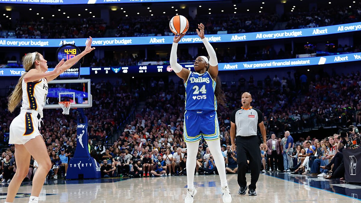 Alt Text: Dallas Wings guard Arike Ogunbowale rises for a jump shot as Indiana Fever guard Lexie Hull closes out.