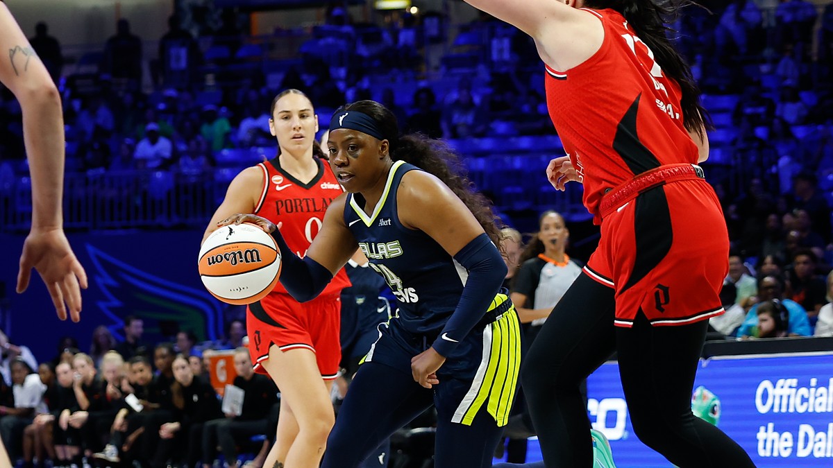 Dallas Wings guard Arike Ogunbowale drives the ball toward the basket past a Portland Fire defender.