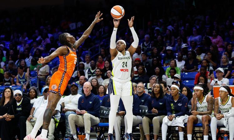 Dallas Wings guard Arike Ogunbowale rises for a three-point shot over a Connecticut Sun defender.