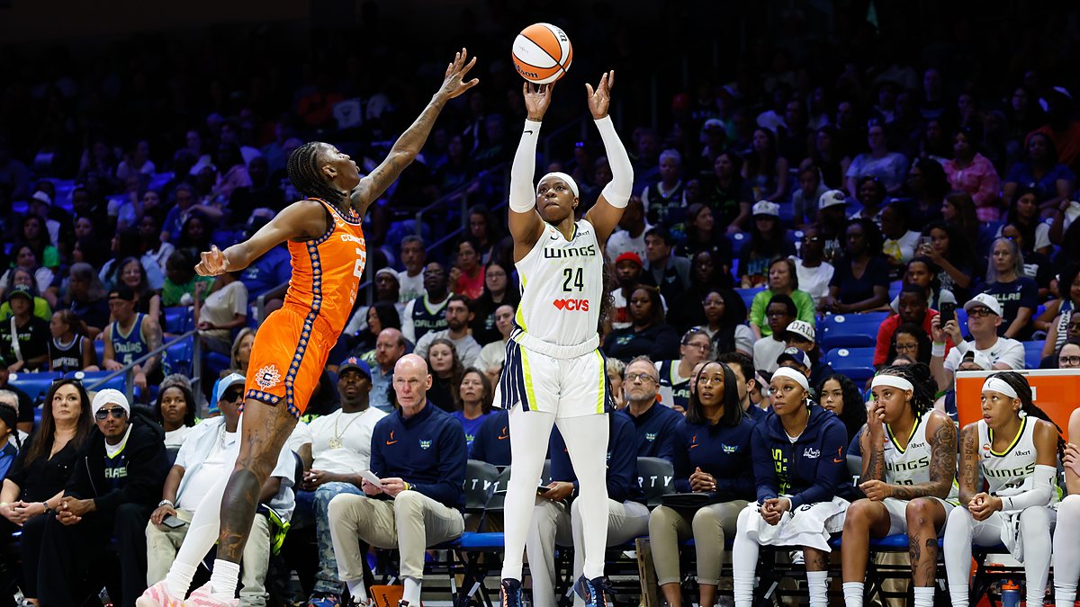 Dallas Wings guard Arike Ogunbowale rises for a three-point shot over a Connecticut Sun defender.