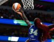Dallas Wings forward Awak Kuier reaches up to block a shot at the rim, shot from behind.