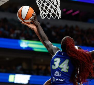 Dallas Wings forward Awak Kuier reaches up to block a shot at the rim, shot from behind.