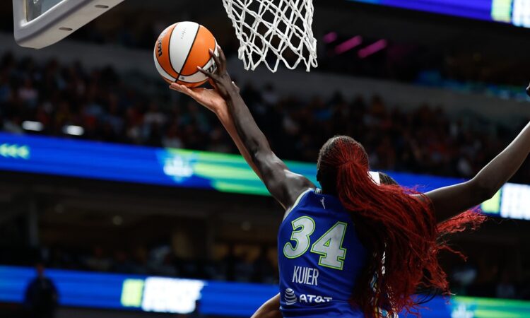 Dallas Wings forward Awak Kuier reaches up to block a shot at the rim, shot from behind.