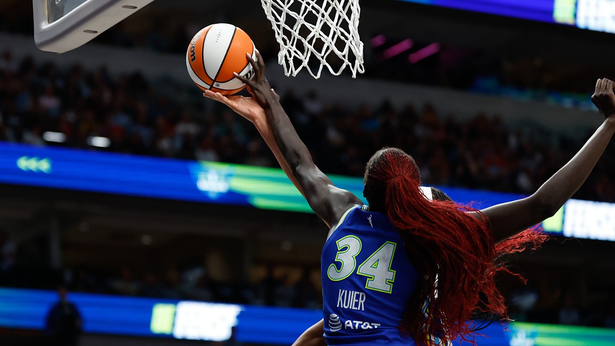 Dallas Wings forward Awak Kuier reaches up to block a shot at the rim, shot from behind.