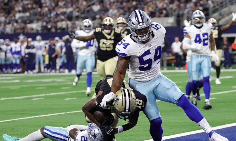 New Orleans Saints wide receiver Barion Brown pulls in a touchdown catch as Cowboys cornerback Caelen Carson falls beneath him.