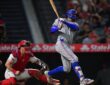 Texas Rangers right fielder Brandon Nimmo follows through on a swing as the Angels catcher watches from his knees.