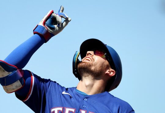 Texas Rangers right fielder Brandon Nimmo points skyward after reaching base at Sutter Health Park.