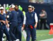 Dallas Cowboys head coach Brian Schottenheimer walks the sideline in a headset, holding a play sheet.