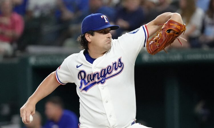 Texas Rangers pitcher Cal Quantrill winds up to deliver a pitch in his white home uniform.