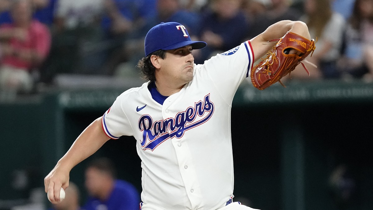 Texas Rangers pitcher Cal Quantrill winds up to deliver a pitch in his white home uniform.