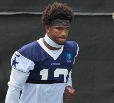 Dallas Cowboys safety Caleb Downs walks the practice field in a navy No. 13 practice jersey and headband.