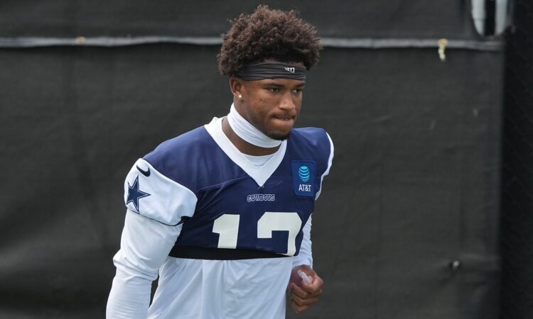 Dallas Cowboys safety Caleb Downs walks the practice field in a navy No. 13 practice jersey and headband.