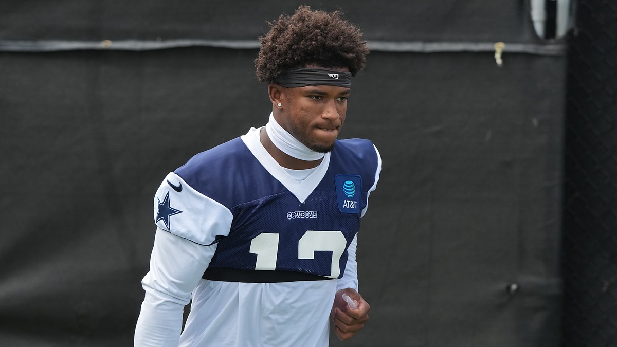 Dallas Cowboys safety Caleb Downs walks the practice field in a navy No. 13 practice jersey and headband.