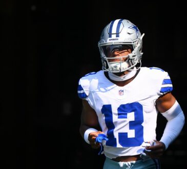 Dallas Cowboys safety Caleb Downs runs out of the tunnel in his white No. 13 jersey, mouthguard in hand.