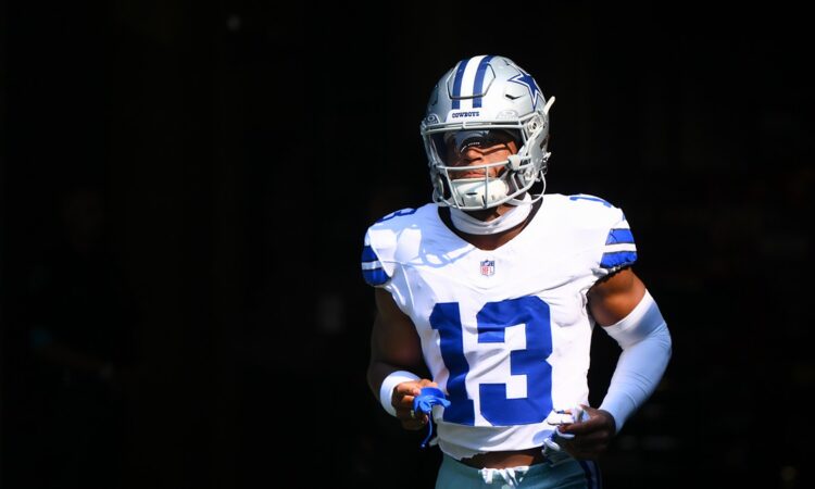 Dallas Cowboys safety Caleb Downs runs out of the tunnel in his white No. 13 jersey, mouthguard in hand.