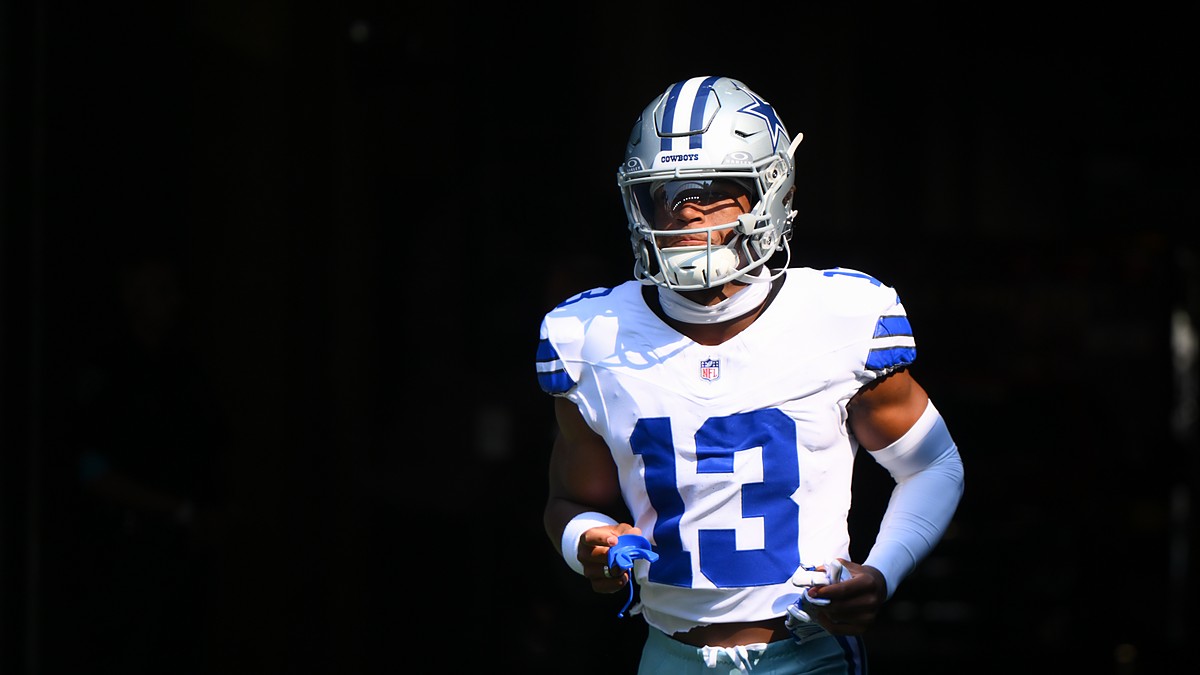 Dallas Cowboys safety Caleb Downs runs out of the tunnel in his white No. 13 jersey, mouthguard in hand.