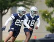 Dallas Cowboys rookie defensive backs Devin Moore and Caleb Downs break into a run during a minicamp drill.
