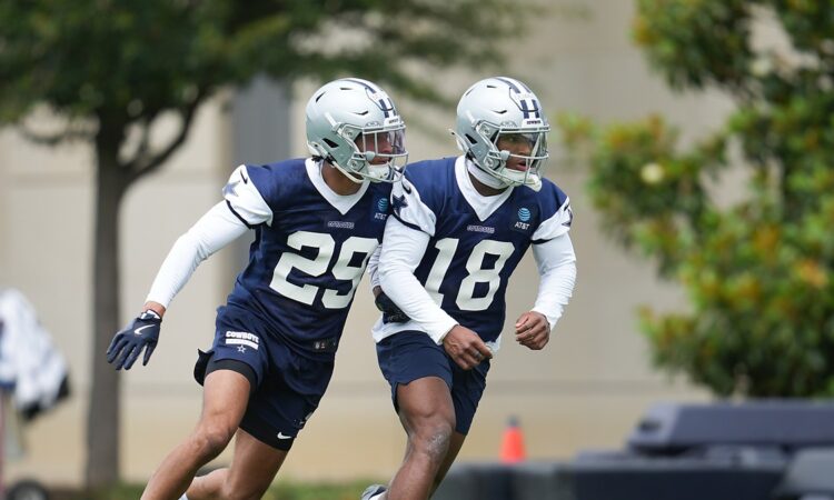 Dallas Cowboys rookie defensive backs Devin Moore and Caleb Downs break into a run during a minicamp drill.