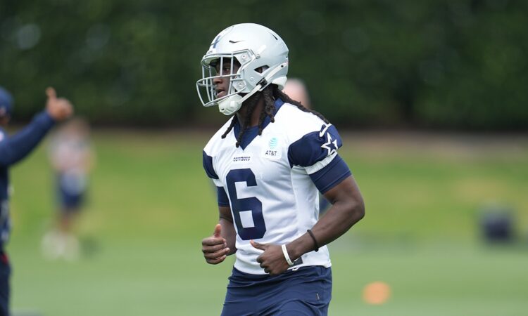 Dallas Cowboys wide receiver Camden Brown jogs across the practice field in a white No. 6 practice jersey and helmet.