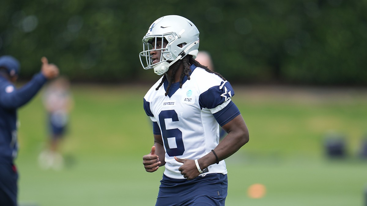 Dallas Cowboys wide receiver Camden Brown jogs across the practice field in a white No. 6 practice jersey and helmet.