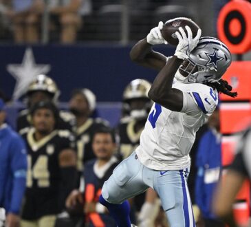 Dallas Cowboys wide receiver Camden Brown leaps and hauls in a pass along the sideline at AT&T Stadium.