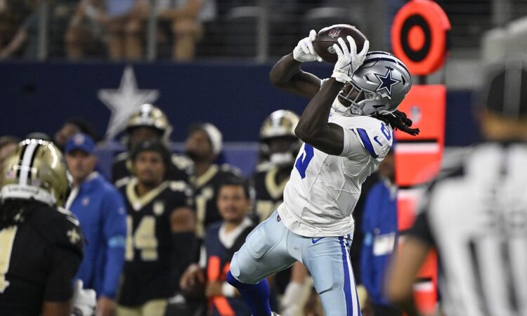 Dallas Cowboys wide receiver Camden Brown leaps and hauls in a pass along the sideline at AT&T Stadium.
