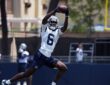 Dallas Cowboys wide receiver Camden Brown extends overhead to haul in a pass during training camp practice.