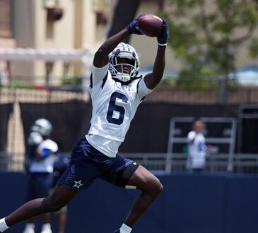 Dallas Cowboys wide receiver Camden Brown extends overhead to haul in a pass during training camp practice.