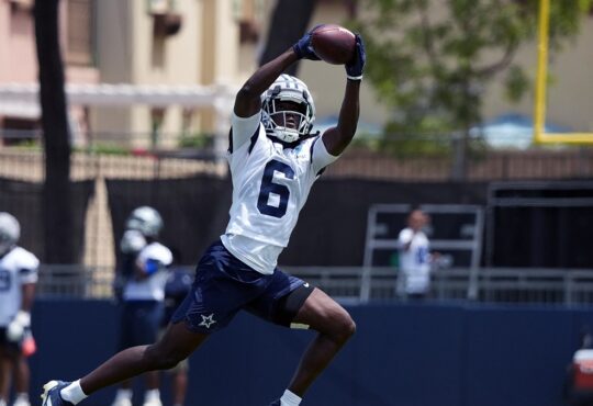 Dallas Cowboys wide receiver Camden Brown extends overhead to haul in a pass during training camp practice.