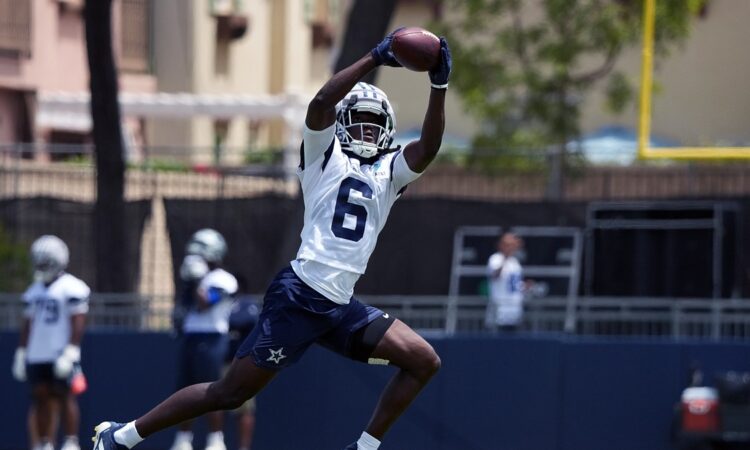 Dallas Cowboys wide receiver Camden Brown extends overhead to haul in a pass during training camp practice.